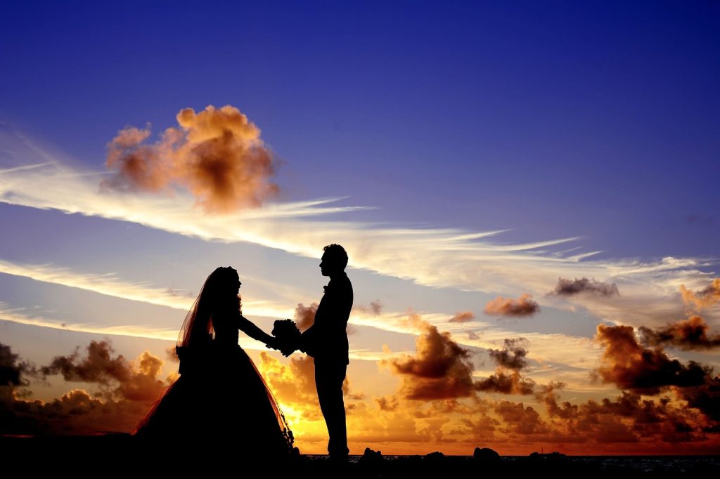 Pareja cogidos de la mano en un atardecer
