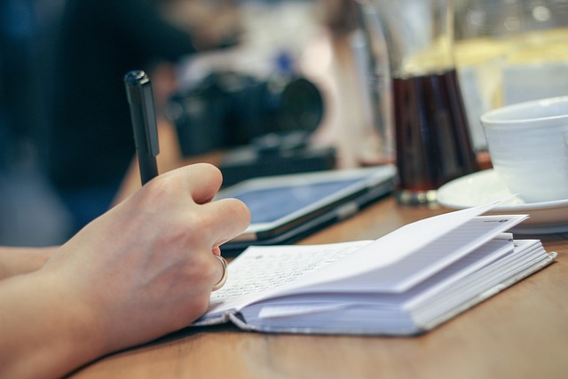 Mano de un oficial de notaría redactando una escritura